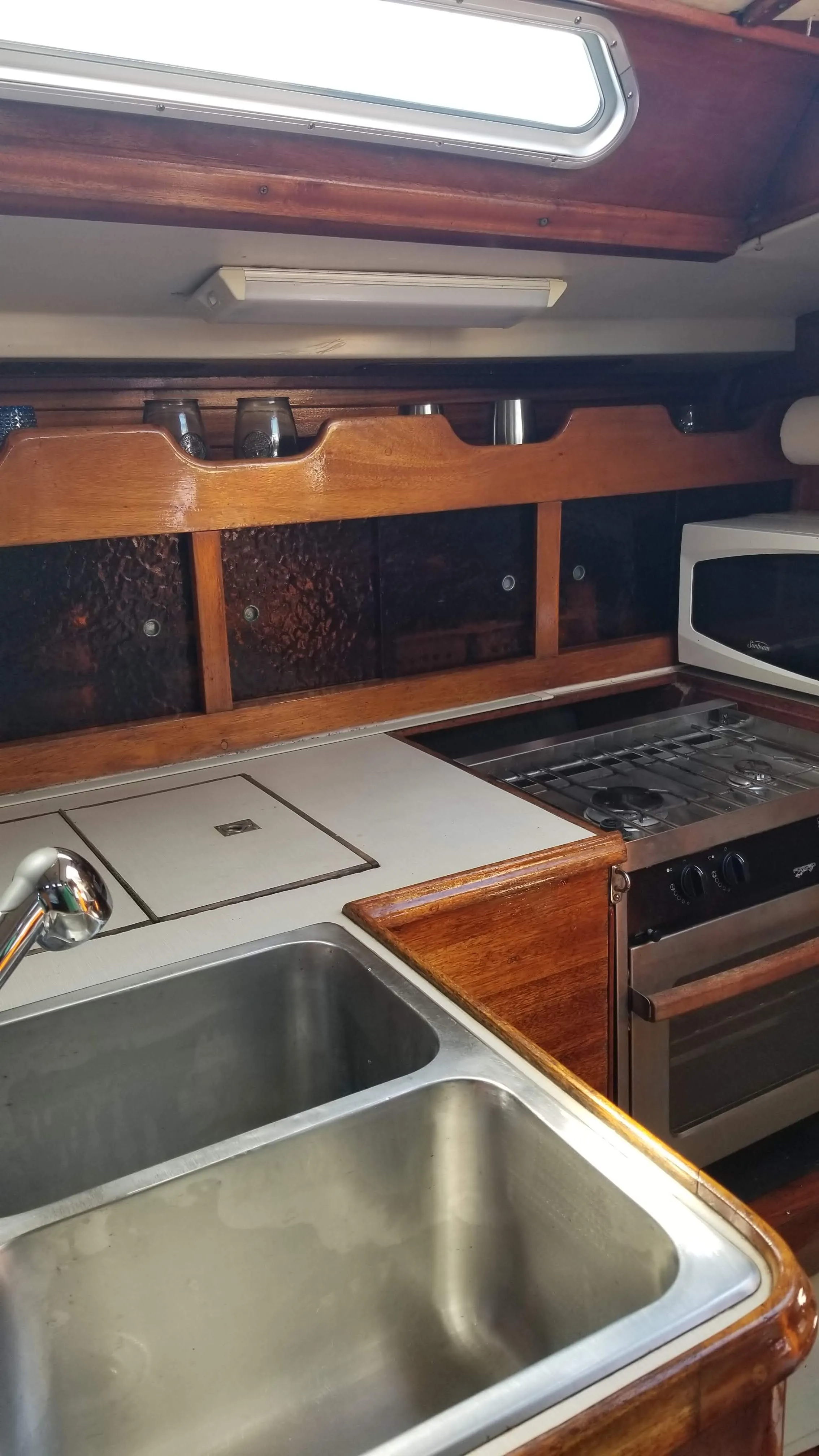 Vertical galley storage and hull-side shelving